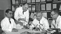 Dr. Mansukh Wani (left), Dr. Monroe Wall (second from right), and fellow researchers examine molecular models.